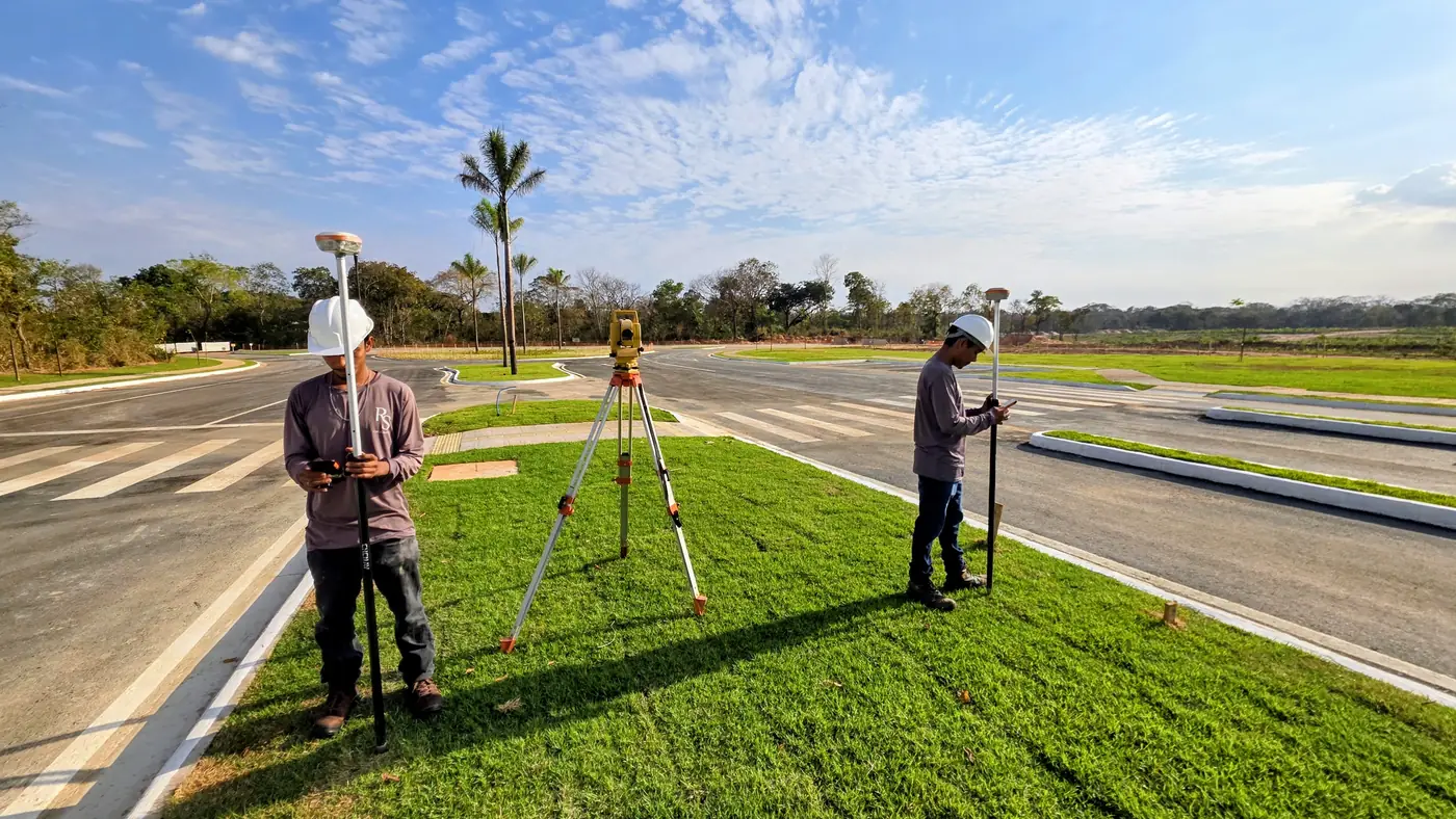 Topógrafo com receptor GPS RTK e estação total em rotatória de loteamento