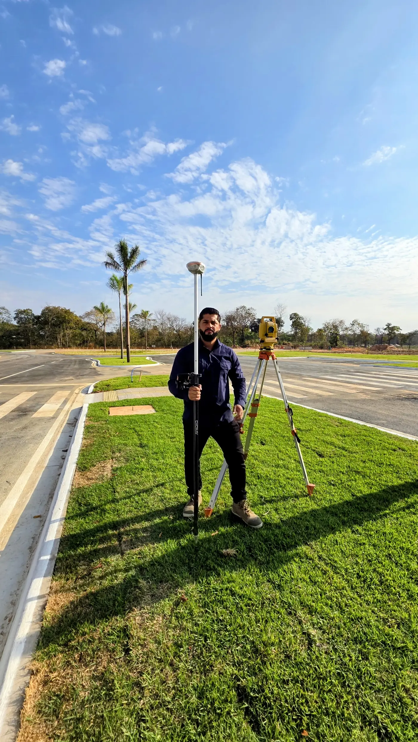Topógrafo com receptor GPS RTK e estação total em rotatória de loteamento